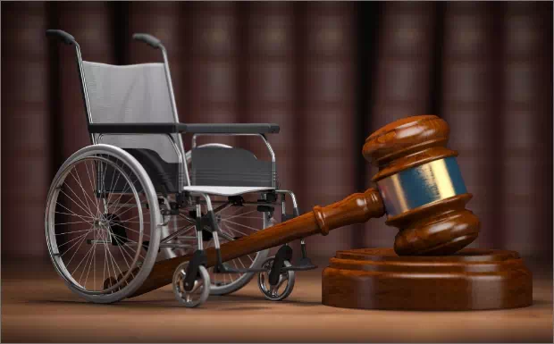 wózek inwalidzki i młotek sądowy